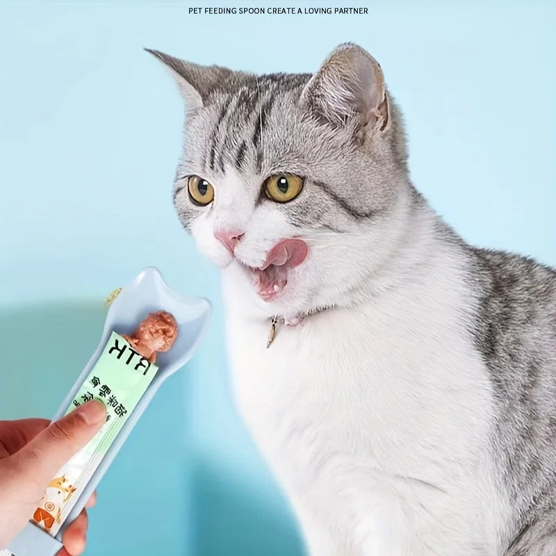 Cat Strip Squeeze Spoon holding pet food packet, designed for easy feeding with a comfortable grip.