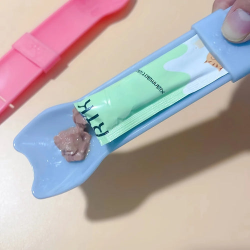 Cat Strip Squeeze Spoon holding pet food packet, designed for easy feeding with a comfortable grip.