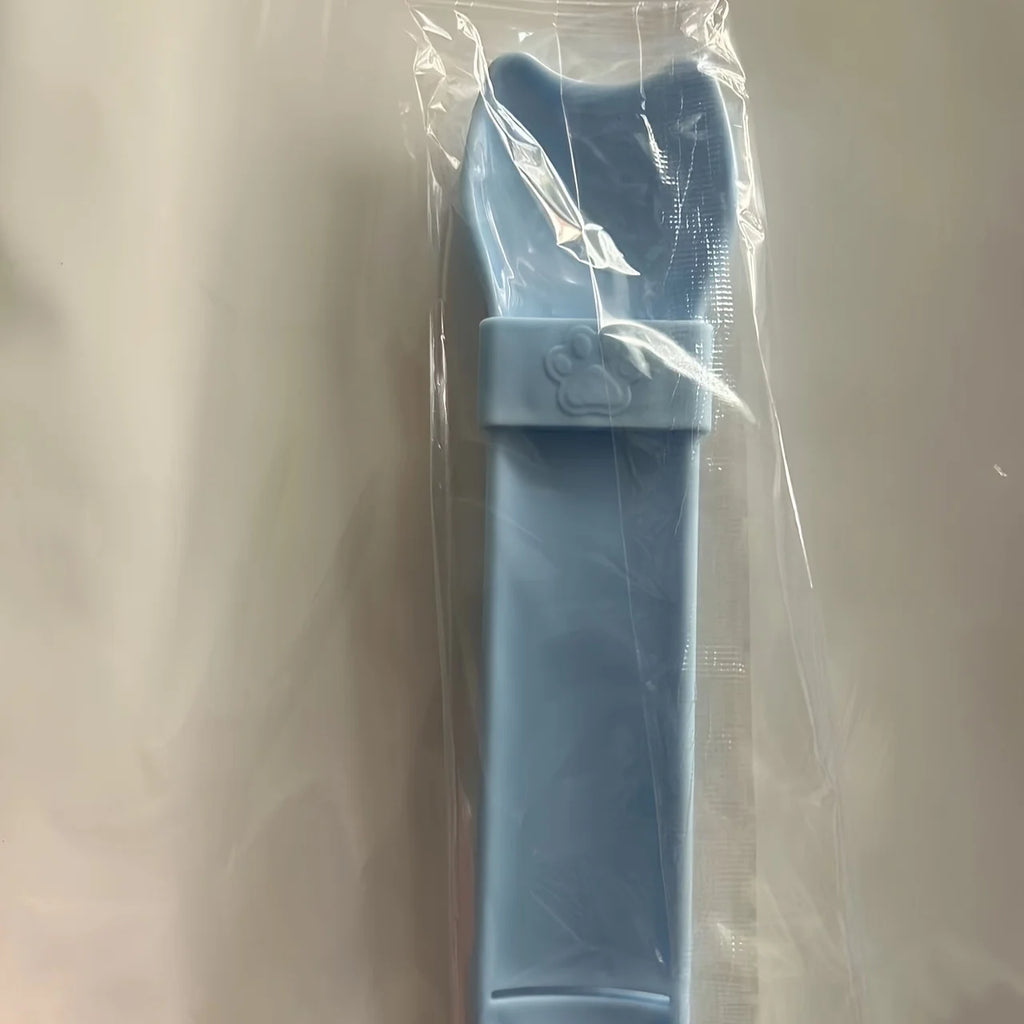 Cat Strip Squeeze Spoon holding pet food packet, designed for easy feeding with a comfortable grip.