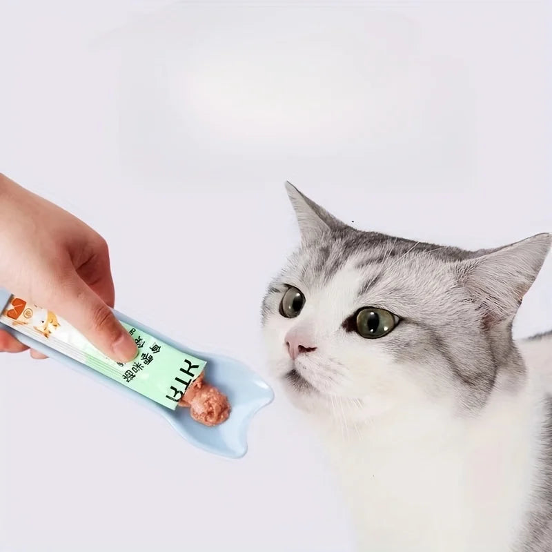 Cat Strip Squeeze Spoon holding pet food packet, designed for easy feeding with a comfortable grip.