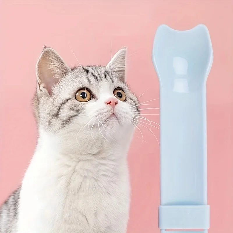 Cat Strip Squeeze Spoon holding pet food packet, designed for easy feeding with a comfortable grip.